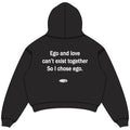 Black oversized cropped hoodie back view with white Ego and love quote and NWAYTA oval logo badge, padded on white square canvas